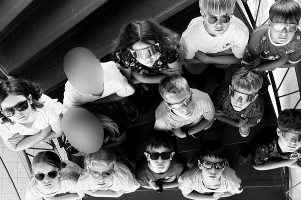Die Schülerinnen und Schüler der Abschlussklasse 2025/26 tragen Sonnenbrillen und blicken gemeinsam nach oben in die Kamera.